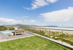 a patio with a bench and a view of the ocean at Cape Beach Villa in Noordhoek
