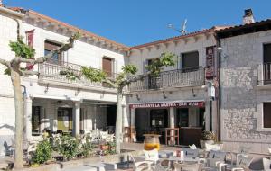 a building with tables and chairs in a courtyard at HOTEL RURAL LOS ABUELOS in Montemayor de Pililla