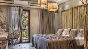 a bedroom with a bed and a sliding glass door at Avithos Resort Hotel in Svoronata