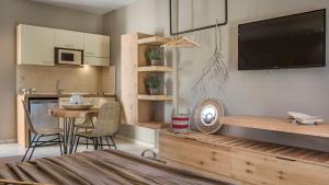 a kitchen and a living room with a tv on the wall at Avithos Resort Hotel in Svoronata