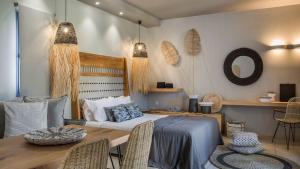 a bedroom with a bed and a table with chairs at Avithos Resort Hotel in Svoronata