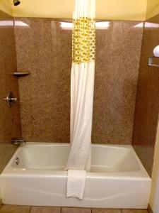 a bath tub with a shower curtain in a bathroom at Crown Inn Motel Yorktown in Yorktown