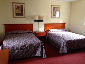 a hotel room with two beds and a red carpet at Crown Inn Motel Yorktown in Yorktown