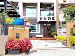 ein Haus mit rosa Blumen davor in der Unterkunft Miao Miao Homestay with Lift in Taitung
