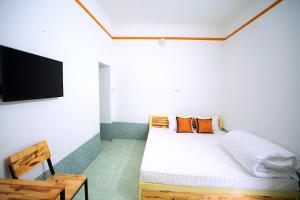 Schlafzimmer mit einem Bett und einem Flachbild-TV in der Unterkunft Tràng an Bái đính Linh homestay Ninh bình in Ninh Bình