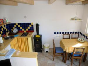 a kitchen with a table and a stove in a room at Lošinj house Robinzon Studenčić Island Lošinj in Cunski
