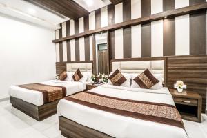 2 camas en una habitación de hotel con paredes a rayas en Hotel Kings, en Amritsar
