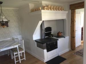 a kitchen with a stove in a room with a table at Stenbrottets lillstuga in Falköping