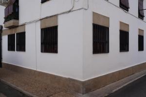 a white building with black barred windows on it at Apartamento Salvador 37 in Almagro