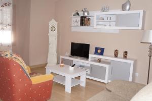 sala de estar con TV, silla y mesa en Apartamento Salvador 37, en Almagro