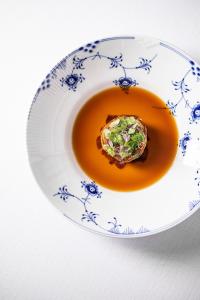 a blue and white plate with a dish of soup at Molskroen in Ebeltoft