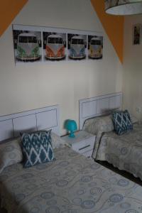 a bedroom with two beds and pictures of buses on the wall at Apartamento Salvador 37 in Almagro