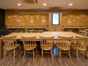 una gran mesa de madera y sillas en una habitación en Super Hotel Hakodate, en Hakodate