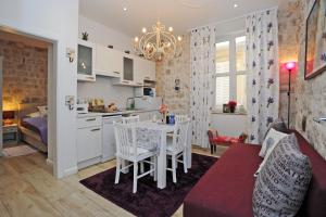 cocina y sala de estar con mesa y sillas en L & L Old Town Apartments, en Dubrovnik