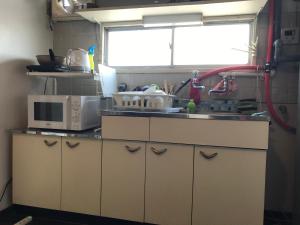 a kitchen with a sink and a microwave at 山下ビル503 in Sutara