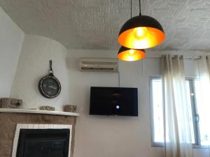 Televízia a/alebo spoločenská miestnosť v ubytovaní Villa Evisa
