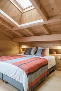 a bedroom with a large bed in a wooden ceiling at Coco Chalet in Arâches-la-Frasse
