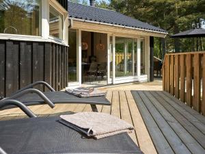 a wooden deck with a table and a patio at 8 person holiday home in Nex in Neksø