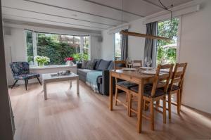 un soggiorno con tavolo e divano di Luxe chalet op de Veluwe a Ermelo