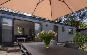 a vase of flowers sitting on a table with an umbrella at Luxe chalet op de Veluwe in Ermelo