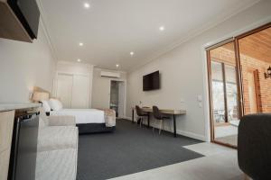 ein Hotelzimmer mit einem Bett und einem Schreibtisch in der Unterkunft Red Waratah Accommodation in Bendigo