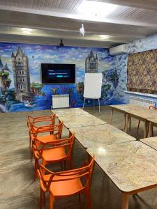 a room with tables and chairs and a mural at Emerald House in Mykulychyn +101 photos