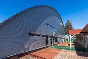 a large metal building with a curved roof at Invest Vendégház in Eger