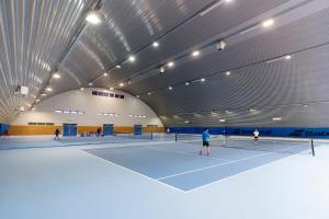 a group of people playing tennis on a tennis court at Invest Vendégház in Eger