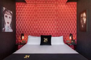 a bedroom with a bed with a red wall at Hugo's Boutique Hotel - Adults Only in St. Julianʼs