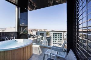 a bath tub on a balcony with a view at Hugo's Boutique Hotel - Adults Only in St. Julianʼs