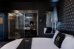 a bedroom with a large white bed and a mirror at Hugo's Boutique Hotel - Adults Only in St. Julianʼs