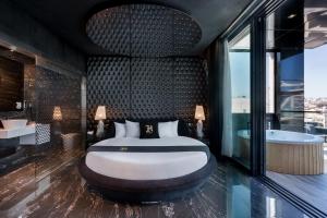 a bedroom with a bed and a tub in a room at Hugo's Boutique Hotel - Adults Only in St Julian's