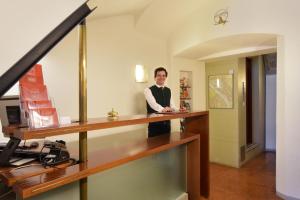 a man standing at a desk in a room at Hotel Wolf in Salzburg