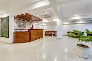 a man standing at the reception desk in a lobby at Ginger Surat City Centre in Surat