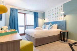 um quarto com uma cama com uma cabeceira azul em Wisteria Hotel em Oakham