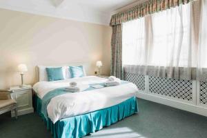 a bedroom with a large bed and a window at St Margaret's Hotel in Oxford