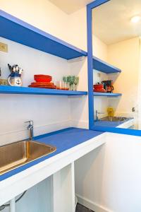 une cuisine avec des étagères bleues et un évier dans l'établissement Viking Hill Oceanfront Hostel & Resort, à Nassau