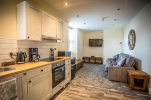 a kitchen with a sink and a couch in a room at Caernarfon Apartments in Caernarfon