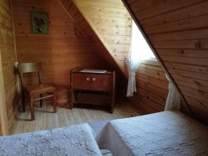 a attic room with a bed and a chair at Ranna Talu Puhkemaja in Kassari