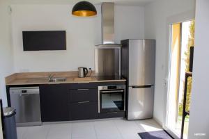 een keuken met een roestvrijstalen koelkast en een wastafel bij BASTIDE 7 in La Fare-les-Oliviers