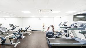a gym with treadmills and elliptical machines at Holiday Inn London Luton Airport, an IHG Hotel in Luton
