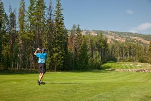 um homem a balançar um taco de golfe num campo de golfe em Polaris Lodge em Kimberley