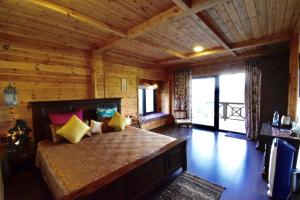 um quarto com uma cama grande num chalé de madeira em Avaas - Bed & Breakfast em Nainital