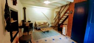 a living room with a staircase and a chair at Une pause sur la colline in Saint-Romain-de-Surieu