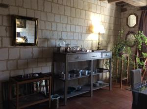 een kamer met een houten tafel en een spiegel bij Manoir Francis in Marles-sur-Canche