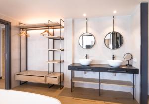 a bathroom with two sinks and two mirrors at Hotel Cap Negret in Altea