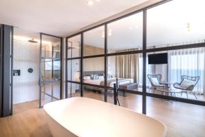 a living room with glass walls and a table at Hotel Cap Negret in Altea