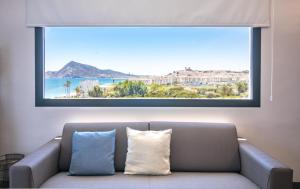 a living room with a couch and a large window at Hotel Cap Negret in Altea