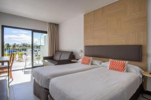 a hotel room with two beds and a balcony at Hotel Cap Negret in Altea