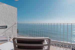 a balcony with a chair and a view of the ocean at Hotel Cap Negret in Altea